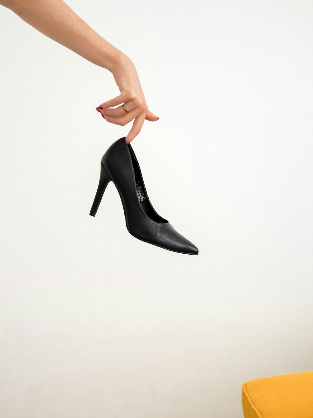 woman in black leather heeled shoes