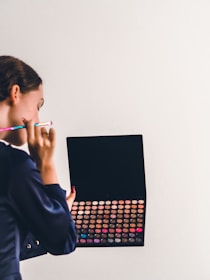 Makeup artist consulting a client with color palettes and brushes.