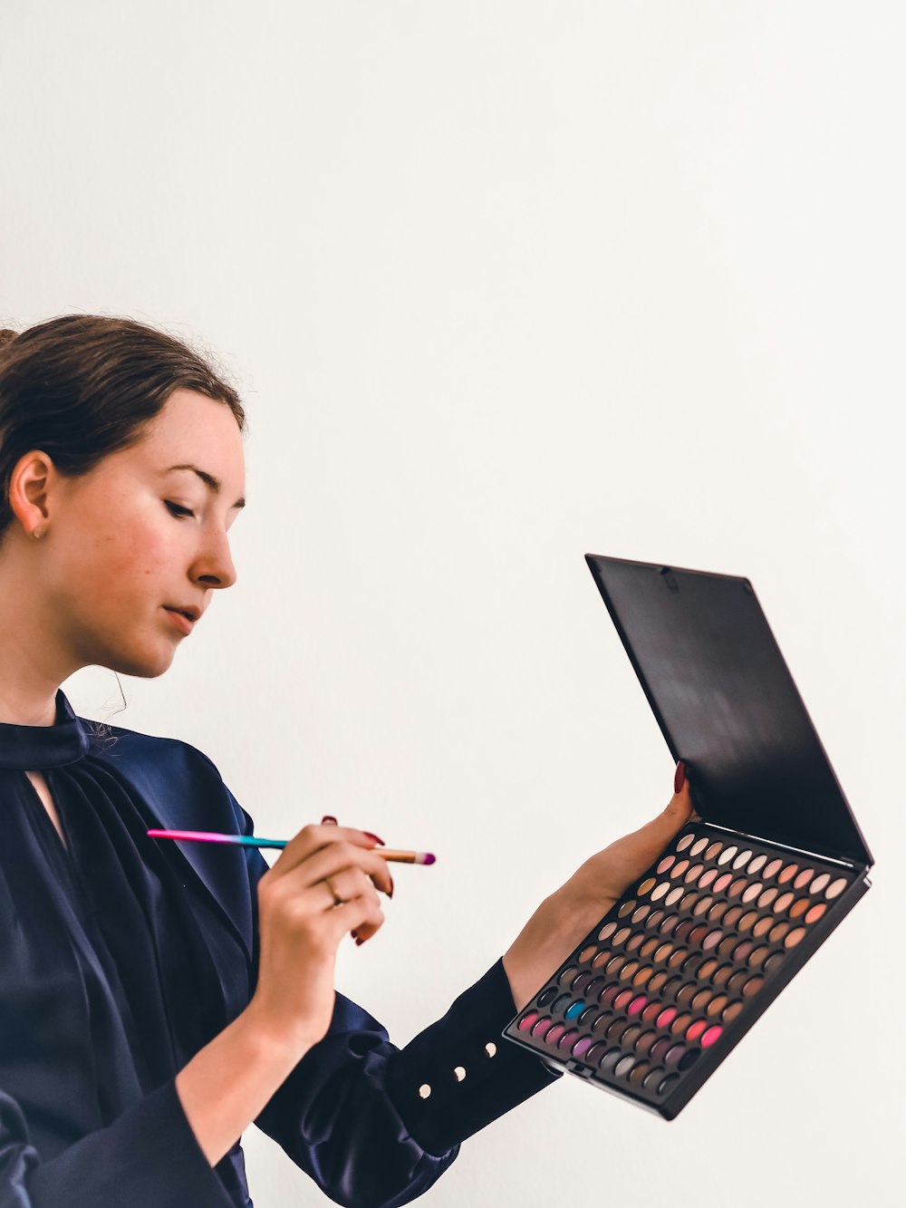 woman in black and blue jacket holding black tablet computer