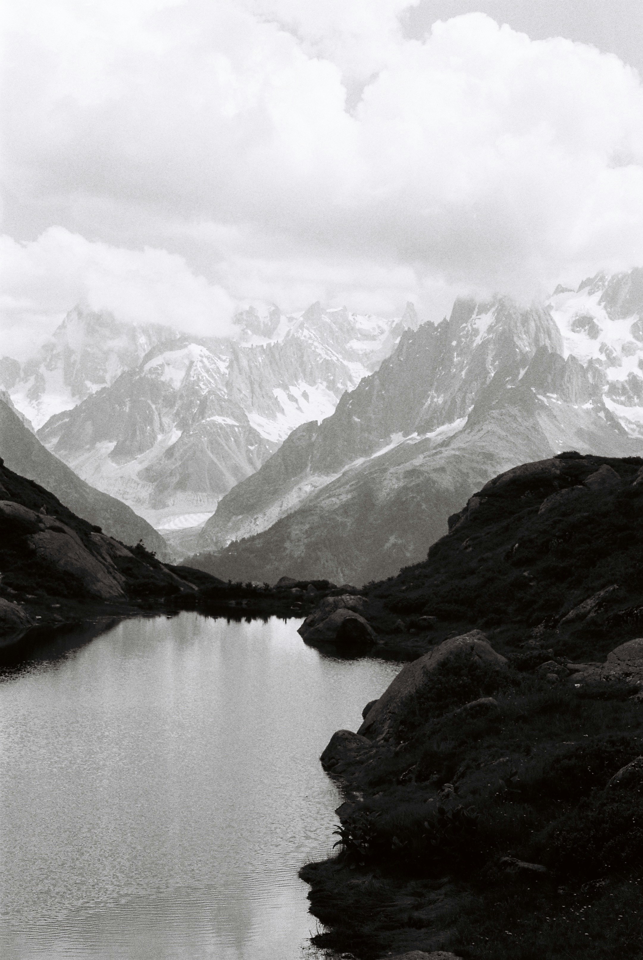 snow covered mountains beside lake during daytime