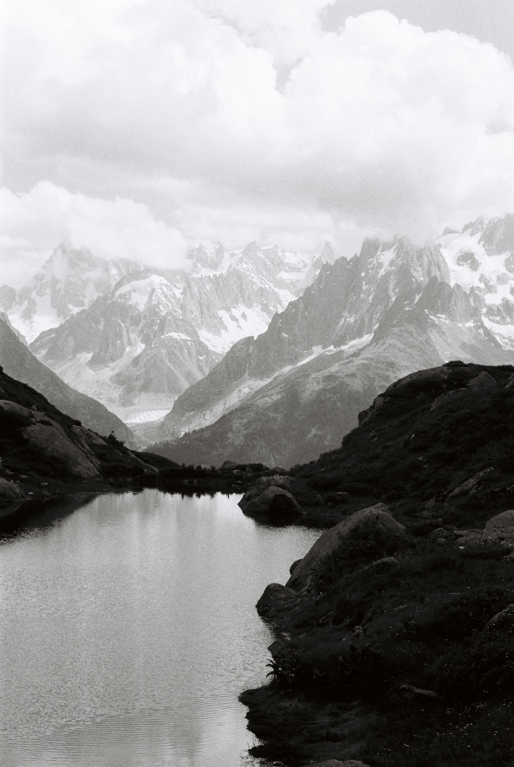 snow covered mountains beside lake during daytime