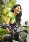 woman in yellow and green dress riding bicycle