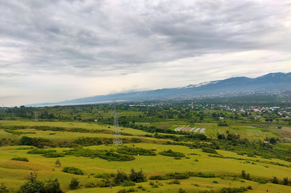 green grass field under cloudy sky during daytime