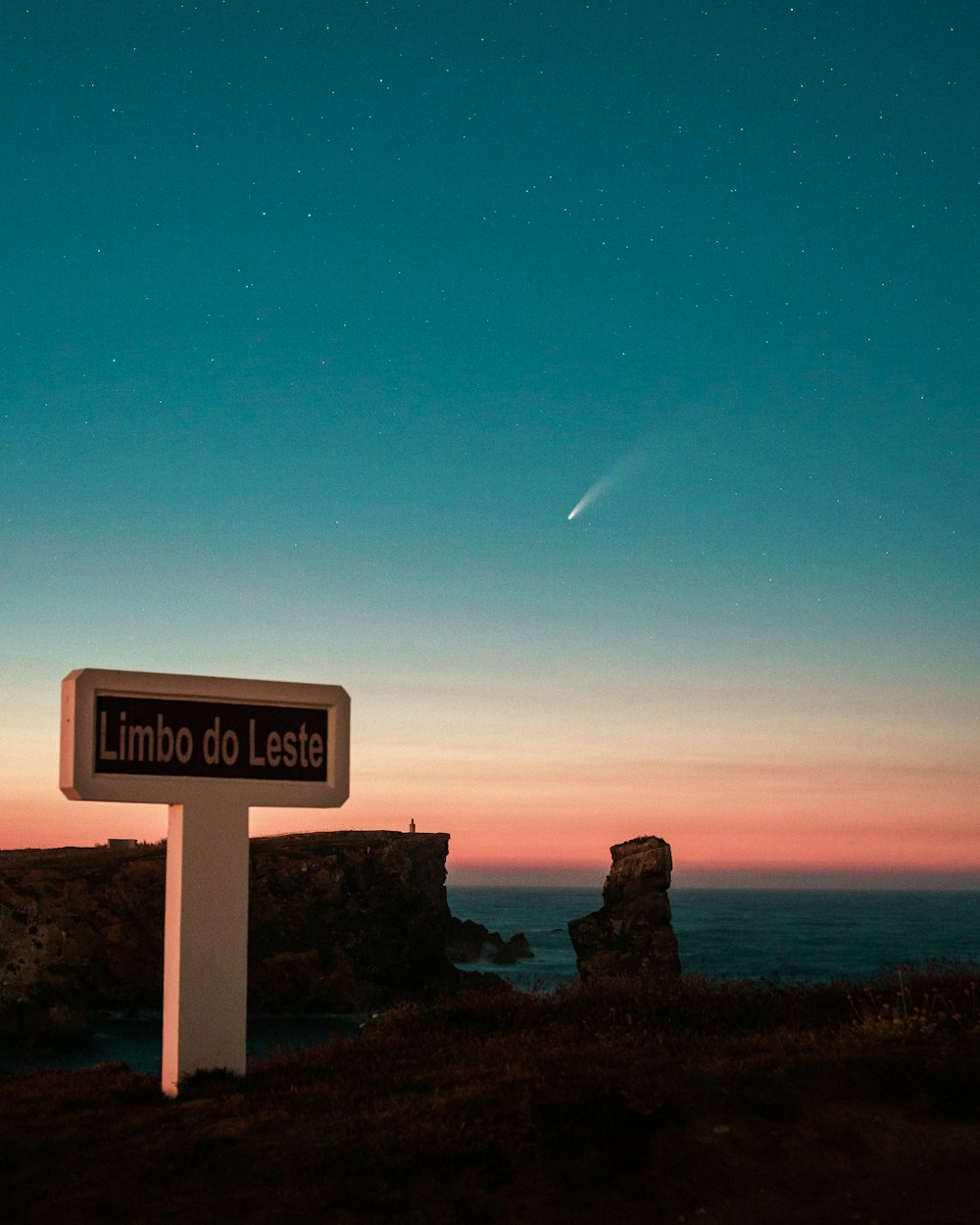 um sinal no lado de uma colina perto do oceano