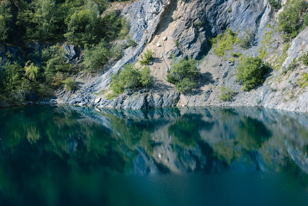 body of water between gray rocky mountain during daytime