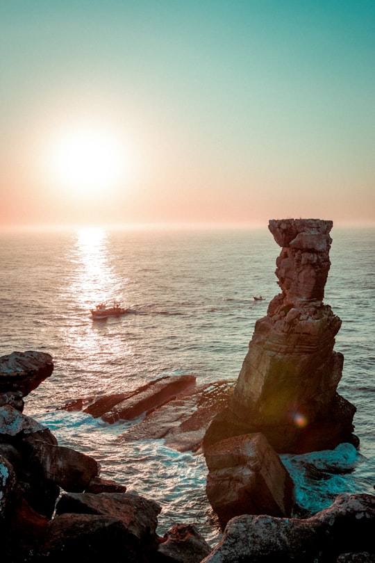 brown rock formation on sea during sunset in Cabo Carvoeiro Portugal