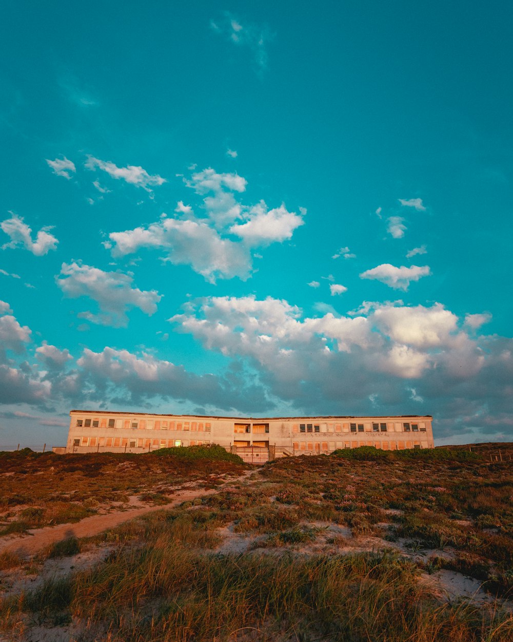 white concrete building under blue sky and white clouds during daytime