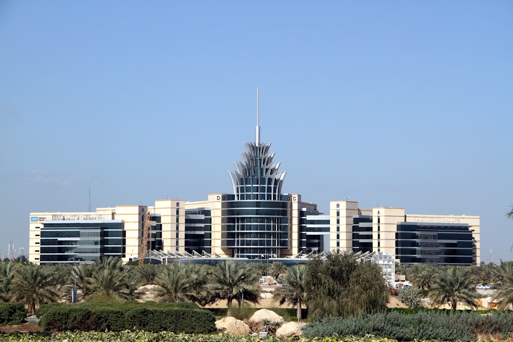 white and blue concrete building near green trees under blue sky during daytime