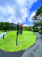 Outdoor totem sign installed in a park area showing clear directional information.