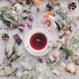 white and pink flower petals beside red and white ceramic mug