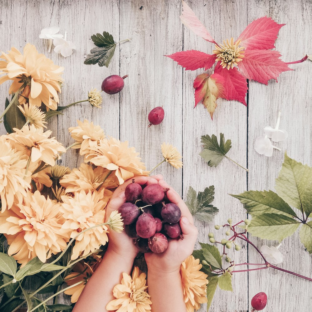 person holding red and yellow flowers