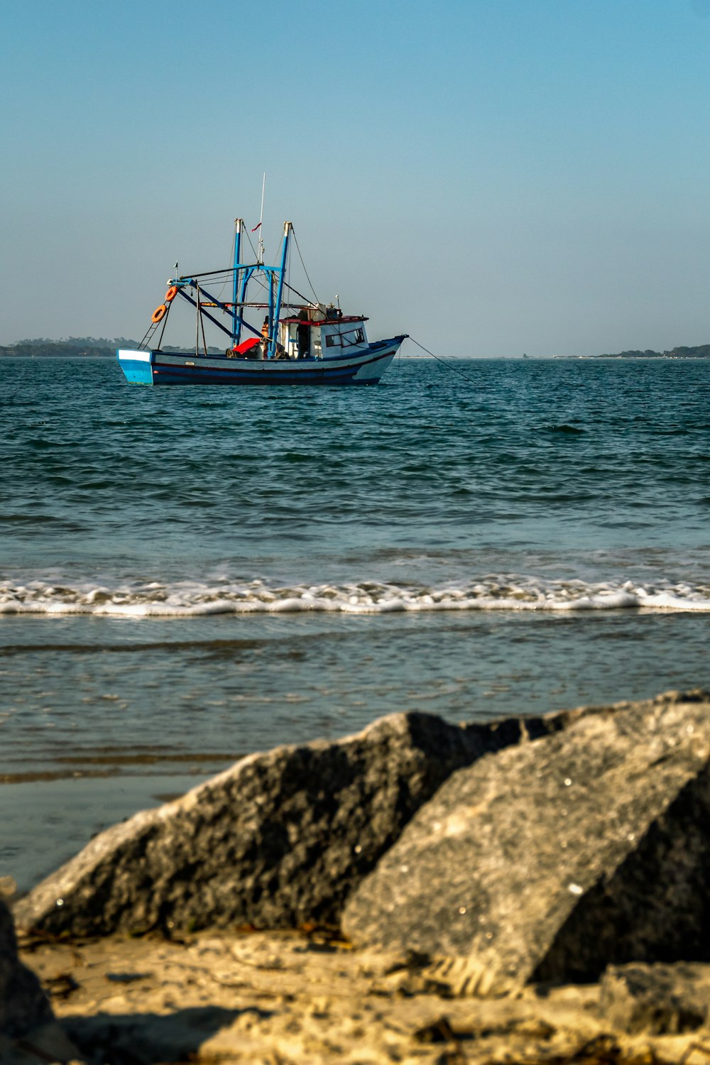 blue and red boat on sea during daytime