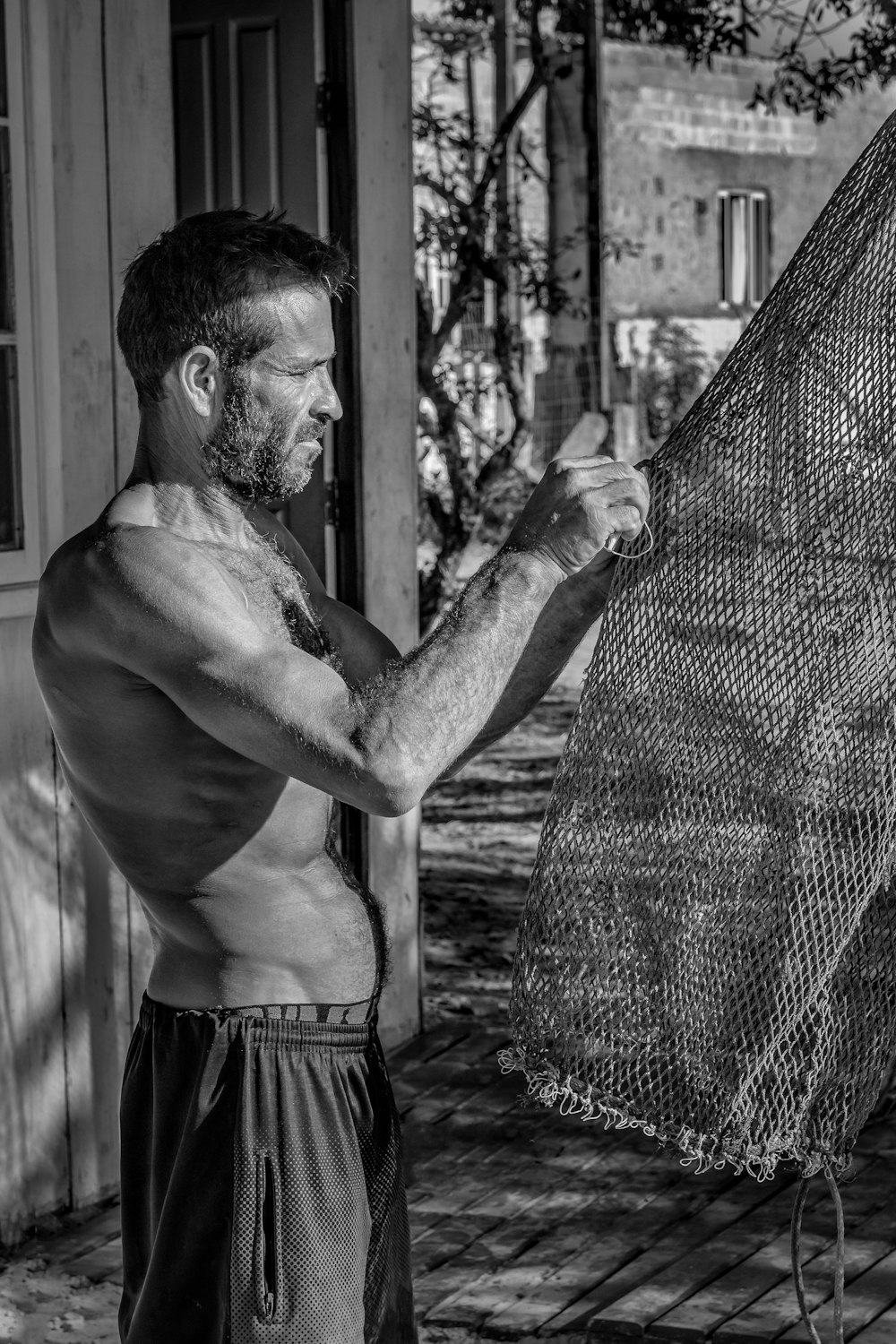 topless man in black shorts standing beside net