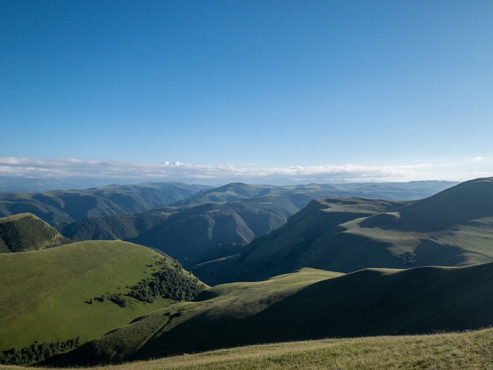 Montañas verdes y marrones bajo el cielo azul durante el día