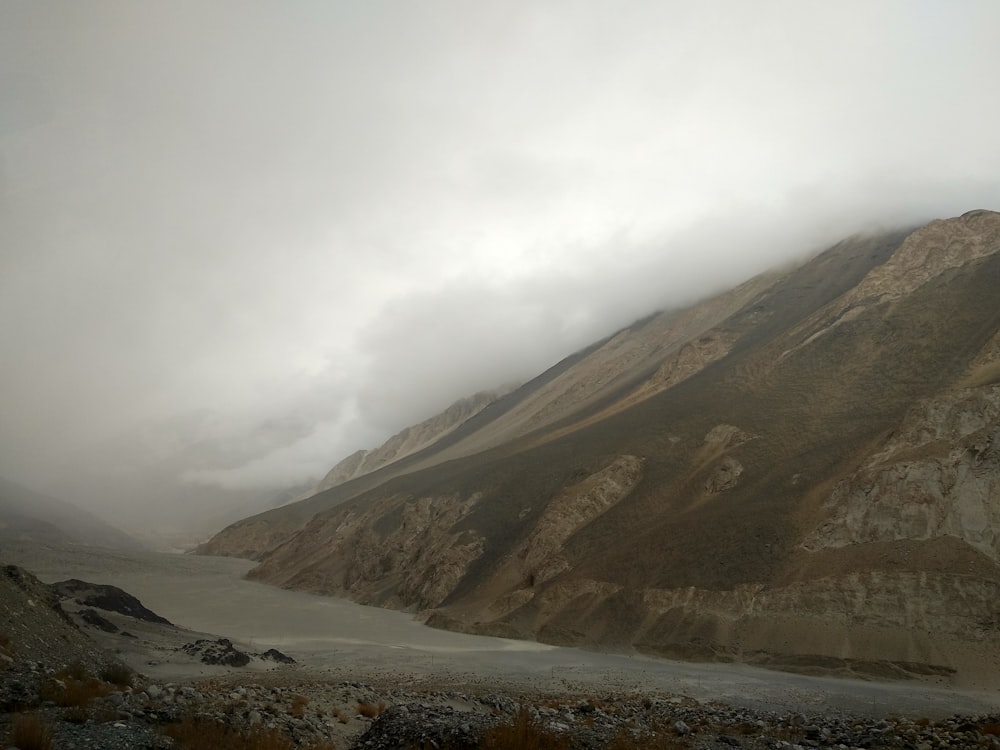 brown and green mountains under white clouds during daytime