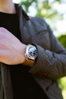 A close-up of a modern watch paired with a leather jacket.