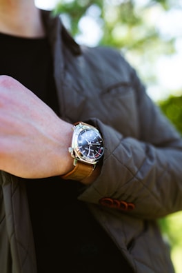 A close-up of a man adjusting his watch, showcasing elegance.