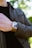 A close-up of a well-dressed man adjusting his watch in a sleek, modern boutique setting.