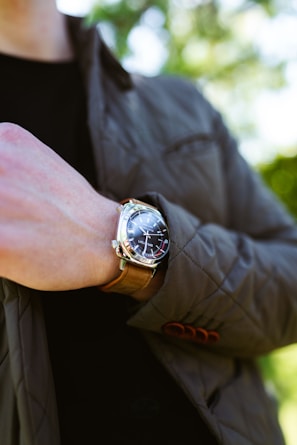 Close-up of a modern watch paired with a leather jacket.