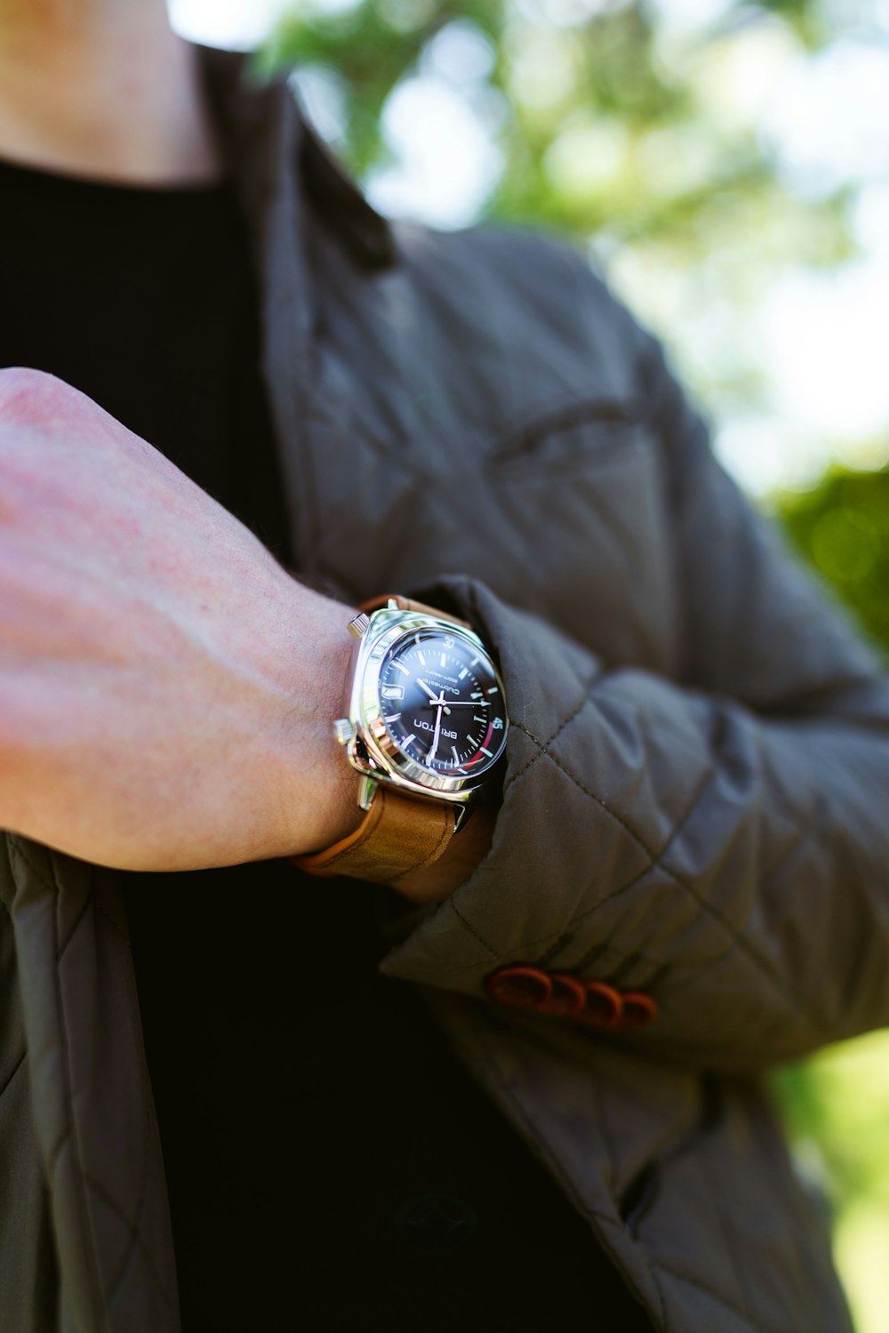 person wearing silver round analog watch