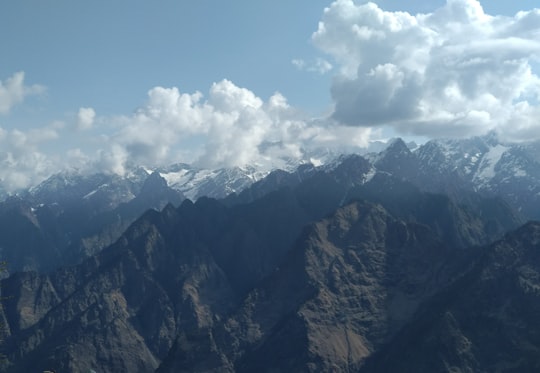 brown and black mountains under white clouds and blue sky during daytime in Auli India