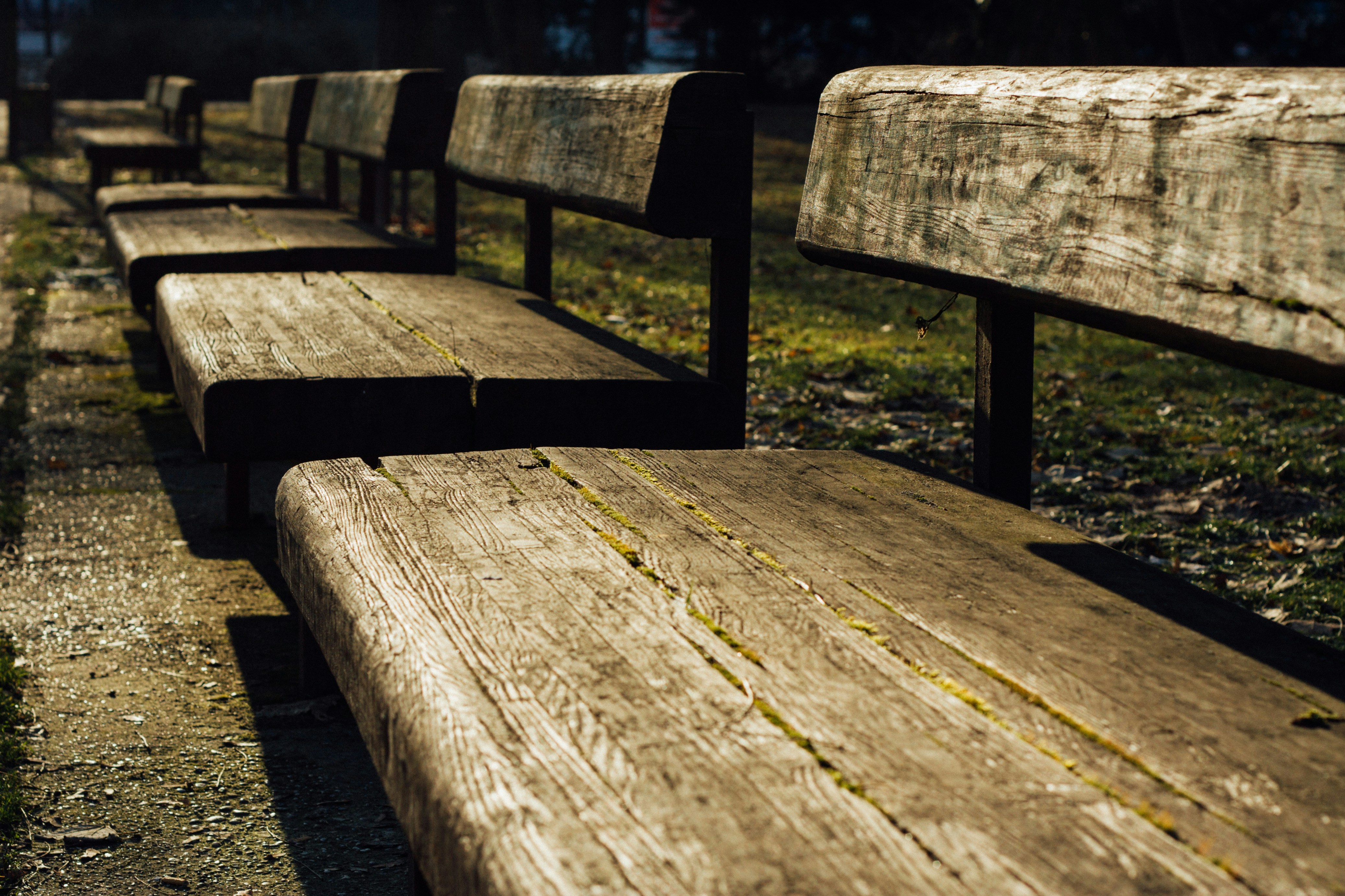 Banco de madera marrón en un campo de hierba verde durante el día