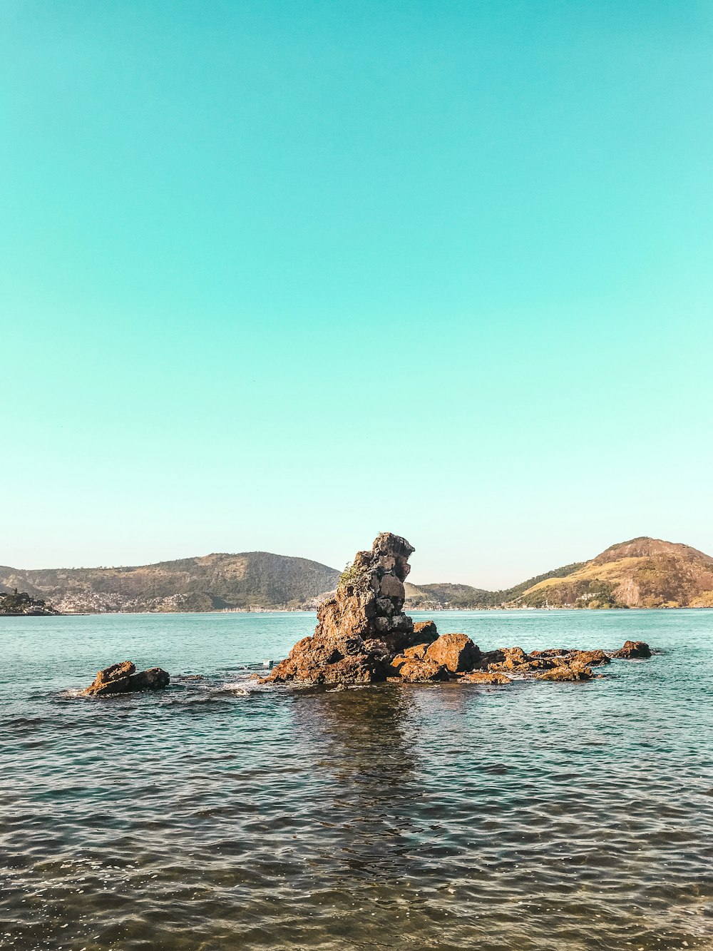 brown rock formation on blue sea under blue sky during daytime