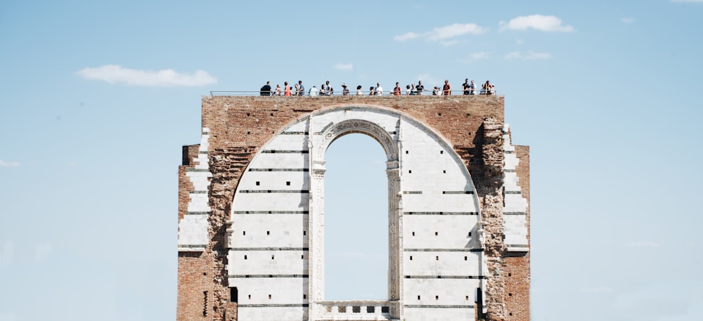 persone che camminano sul cancello dell'arco durante il giorno