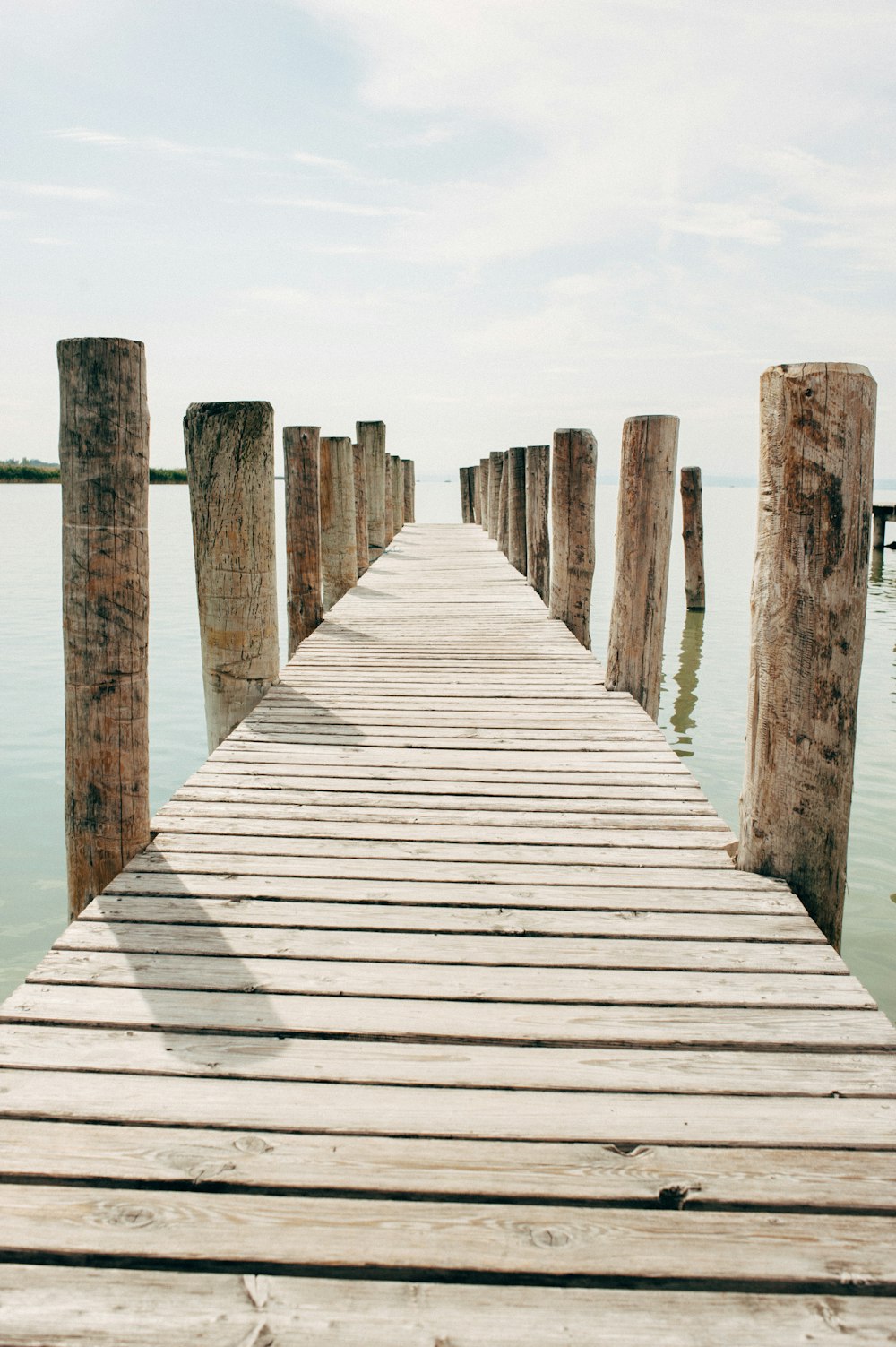 Muelle de madera marrón en el cuerpo de agua durante el día