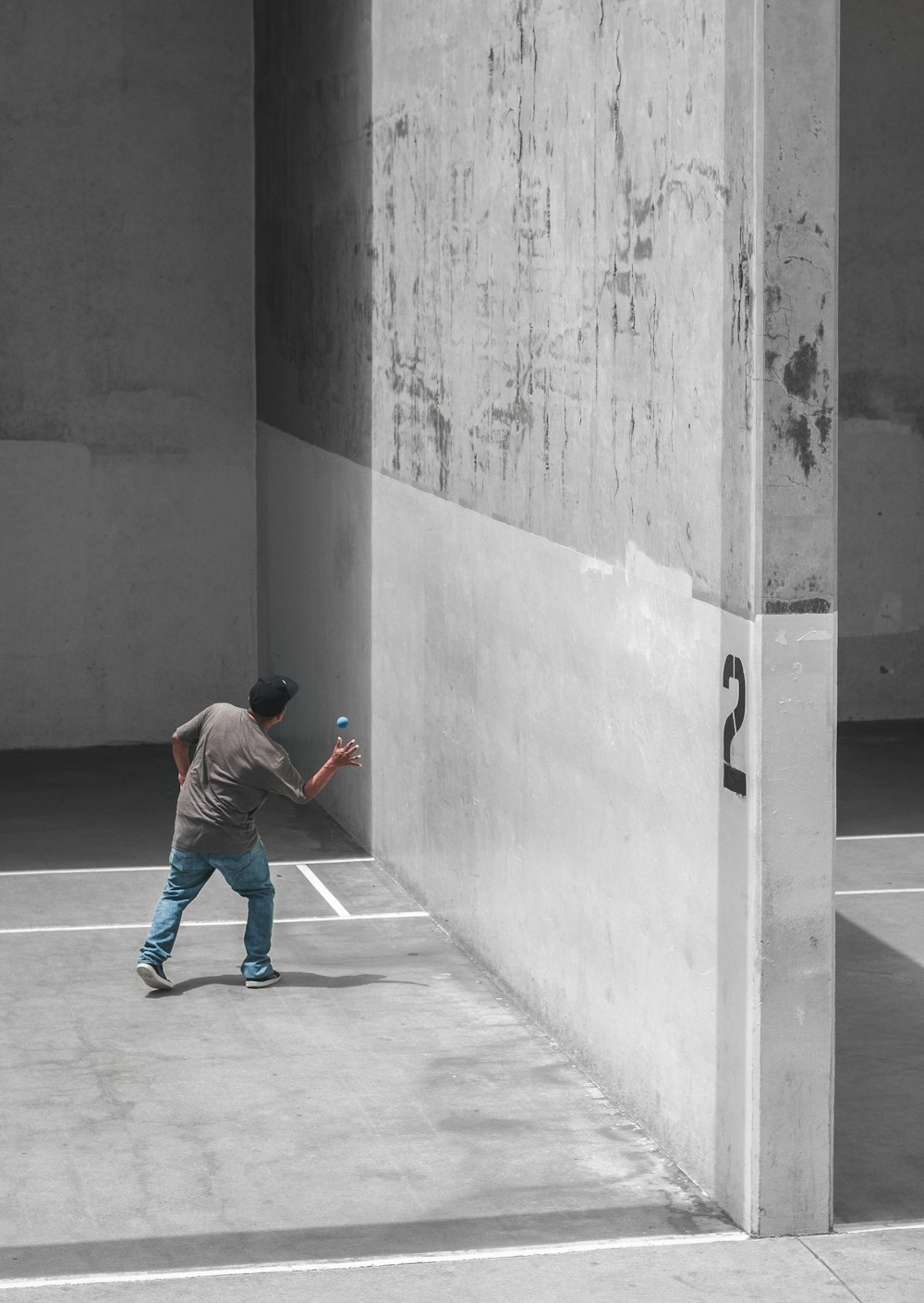 boy in red hoodie and blue denim jeans walking on gray concrete floor