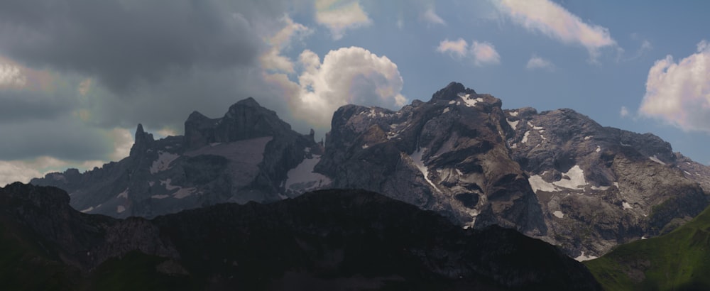 white clouds over black and white mountains