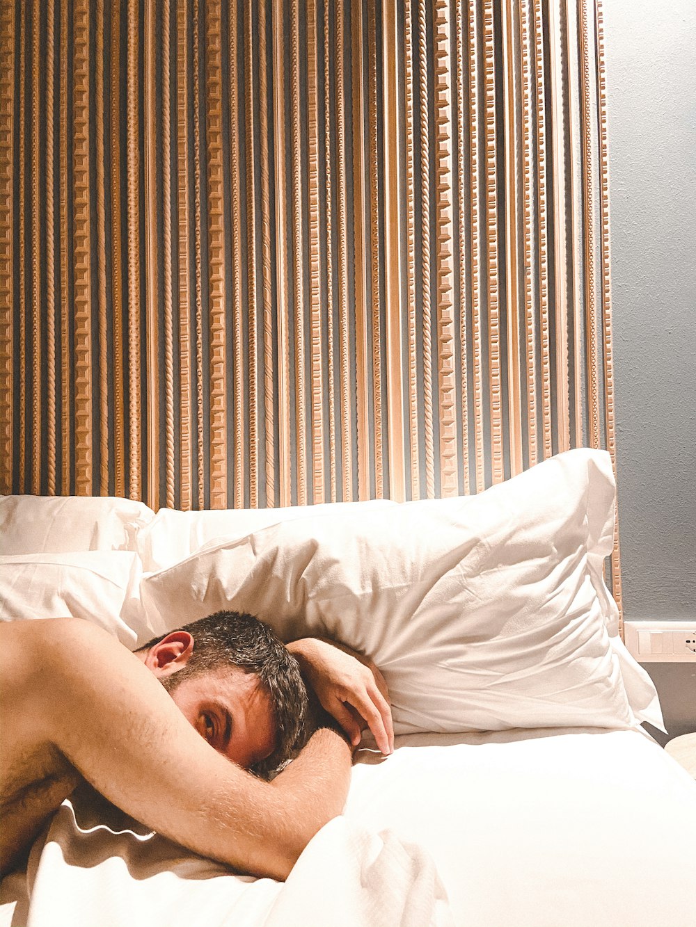 topless man lying on bed