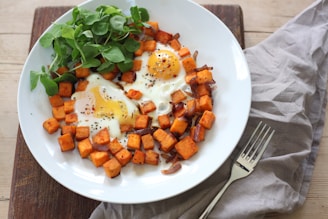 sliced carrots and green vegetable on white ceramic plate