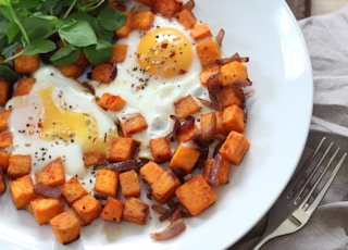 sliced carrots and green vegetable on white ceramic plate