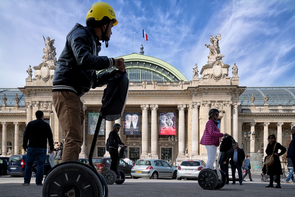 man in black jacket and yellow helmet riding on bicycle during daytime