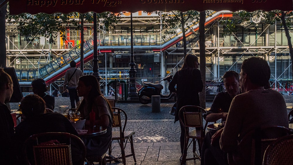 people sitting on chair near store during night time