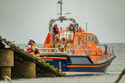 Rescue team helping crew members safely onto a support boat.