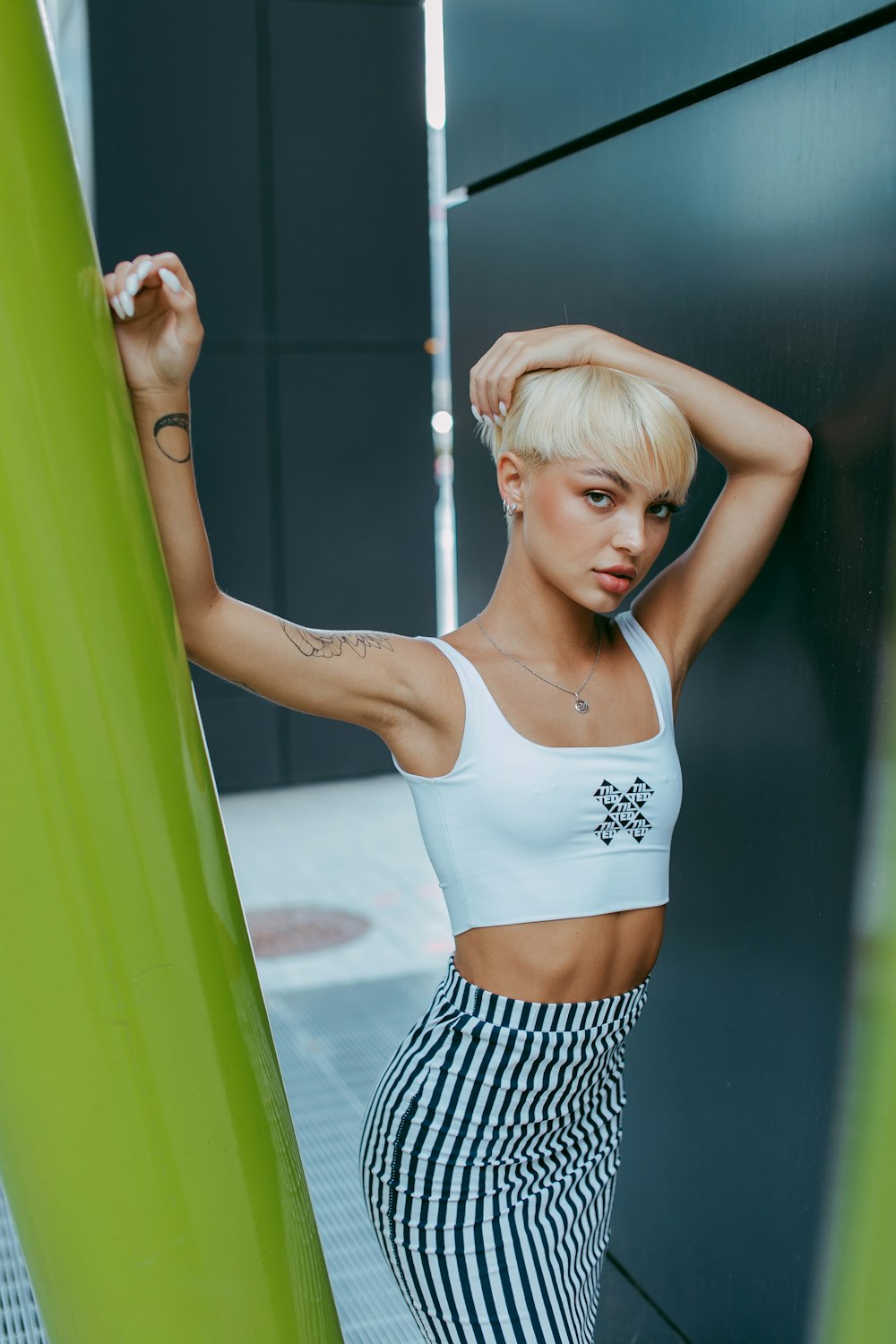 woman in white tank top and black and white striped skirt