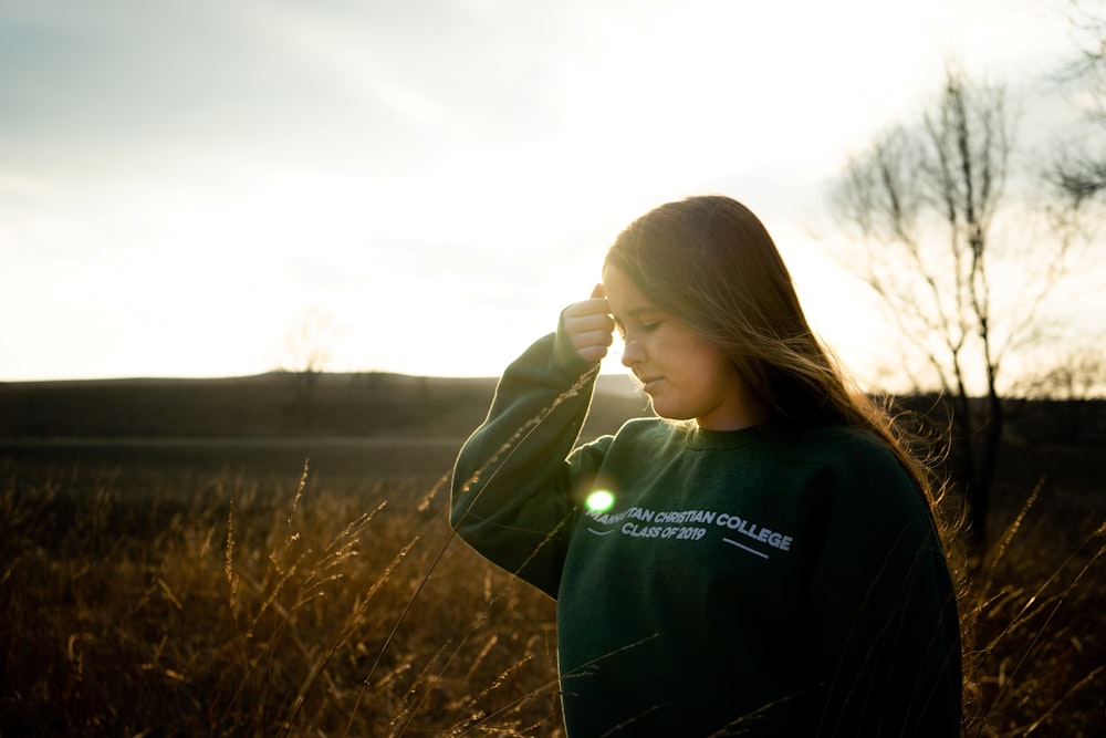 woman in black hoodie standing on brown grass field during daytime