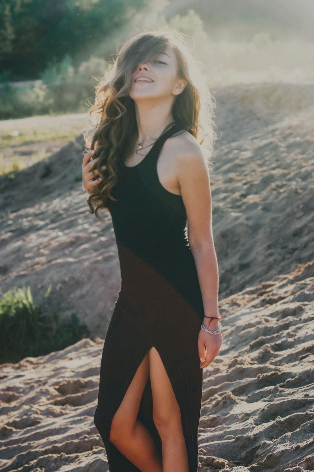 woman in black tank top standing on brown sand during daytime