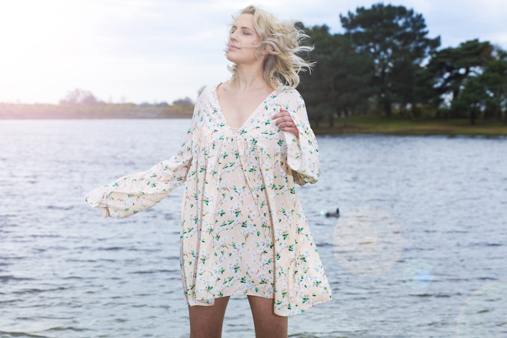 woman in pink and white floral dress standing on water during daytime