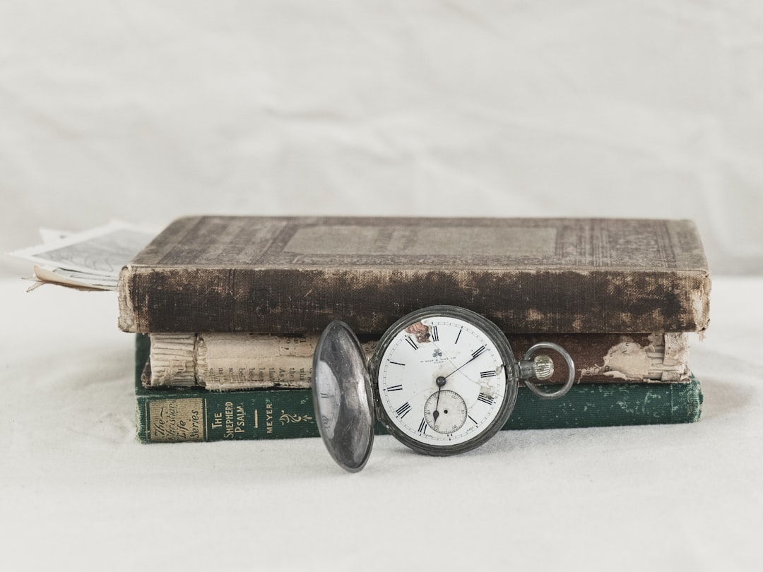 silver round analog watch on brown wooden box