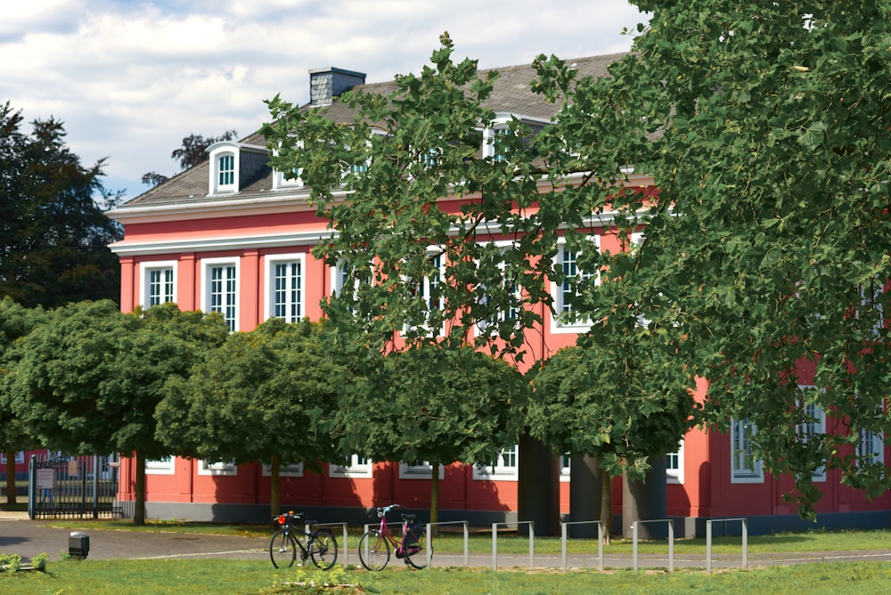 rot-weißes Betongebäude in der Nähe von grünen Bäumen tagsüber