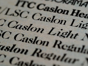 Close-up of elegant typography samples on beige background with gold accents.