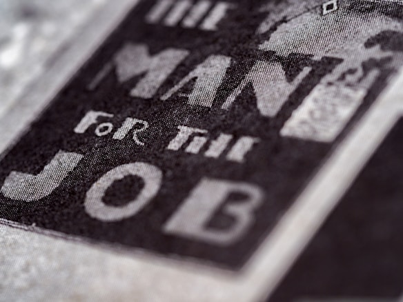 Close-up of text reading 'The Man For The Job' in bold, prominent letters on a textured surface, suggesting a vintage or classic style.