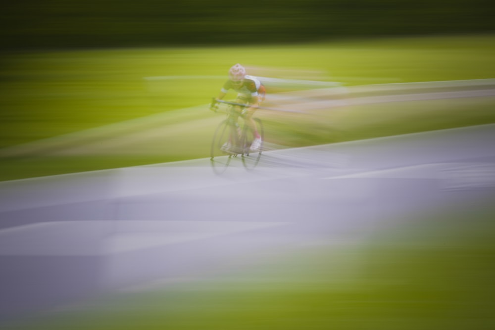 man in yellow shirt riding bicycle on road during daytime