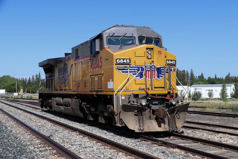 Tren amarillo y negro en las vías del tren durante el día