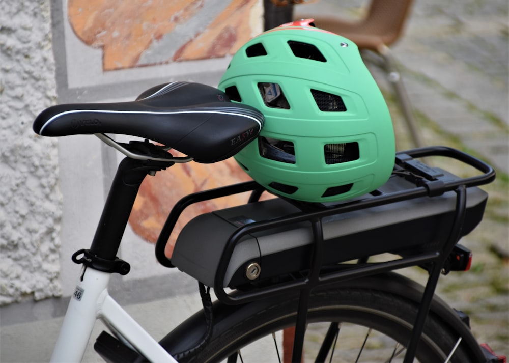 green and black bicycle helmet on bicycle handle bar