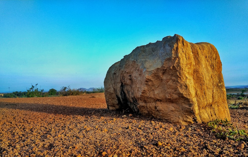 brown rock formation on brown field under blue sky during daytime