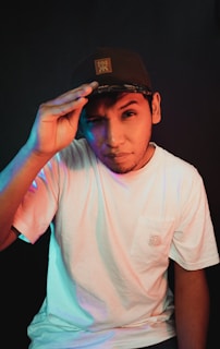 Close-up of hands adjusting a Lumina Apparel cap against a backdrop of urban architecture.